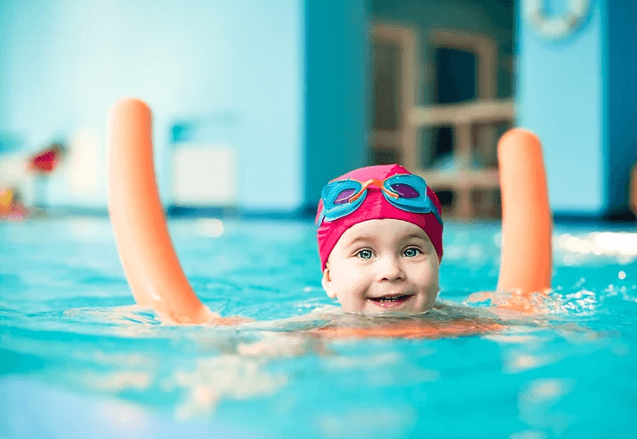 Little girl smiling in swimming pool