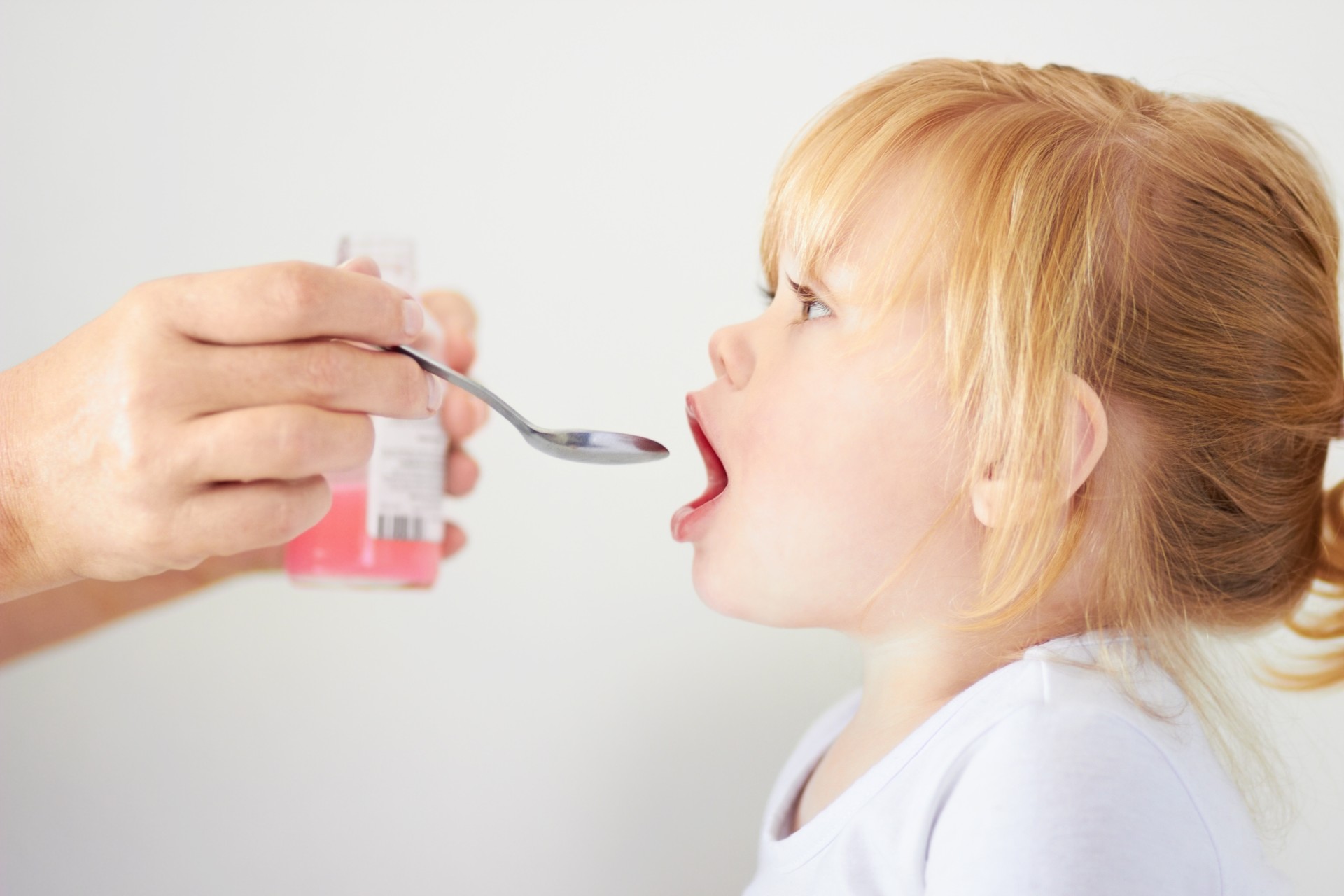 Girl taking a spoonful of medicine