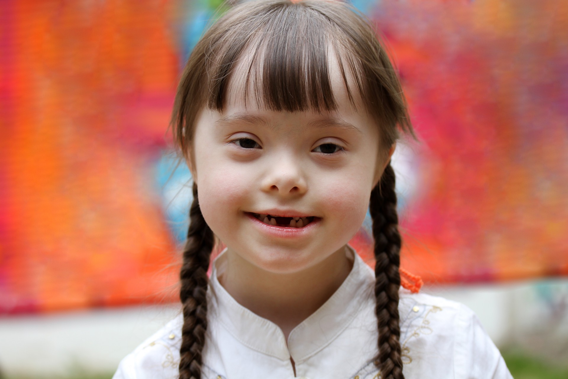 Portrait of little girl smiling on background of the colorful wall